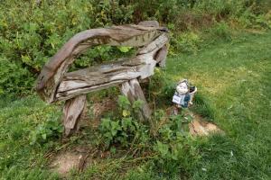 a wooden bench with a fire hydrant in the grass at Teeny Tiny Tipi lakeside pod in Clare