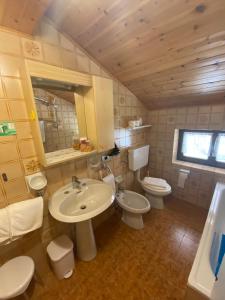 La salle de bains est pourvue de 2 toilettes, d'un lavabo et d'un miroir. dans l'établissement Garni al Barance, à Selva di Cadore