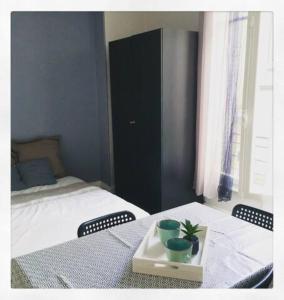 Studio cosy proche parcs, opéra, centre ville في فيشي: غرفة نوم بها سرير وطاولة عليها صينية عليها نبتة