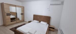 ein Schlafzimmer mit einem Bett und einem großen Spiegel in der Unterkunft Apartament 2 camere cu 2 bai Mamaia Butoaie in Mamaia