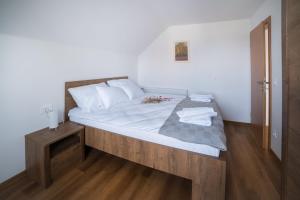 Schlafzimmer mit einem großen Bett mit einem Kopfteil aus Holz in der Unterkunft Apartma Lida 2 in Bled