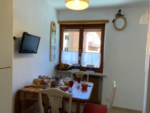 eine Küche mit einem Tisch mit Stühlen und einem Fenster in der Unterkunft Casa Orchidea Bianca by Holiday World in Limone Piemonte