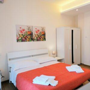 a bedroom with a red bed with two towels on it at In City-In in Catania