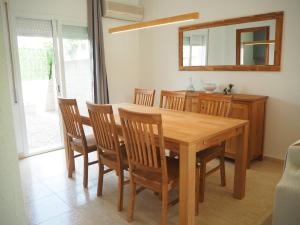 a dining room with a wooden table and chairs at Casa a L’Escala, piscina comunitaria, Mallols in L'Escala