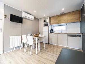 a kitchen and dining room with a table and chairs at Camping Paradis 4 étoiles Au Port de L'Houmeau - La Rochelle in LʼHoumeau