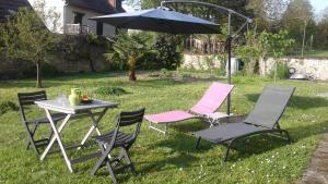 una mesa con sillas y una sombrilla en el césped en Mini Gite Les Marais Beaugency, en Beaugency