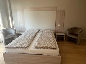 een bed in een kamer met 2 stoelen en een bed sidx sidx sidx bij Villa Belvedere in Gargnano