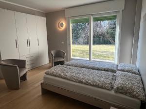 1 dormitorio con cama y ventana grande en Villa Belvedere en Gargnano