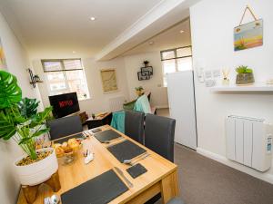 a dining room with a table and a refrigerator at Lighthouse Lofts - St Anthony in Camborne