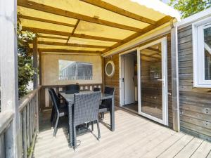 a patio with a table and chairs on a deck at Camping Paradis 4 étoiles Au Port de L'Houmeau - La Rochelle in LʼHoumeau