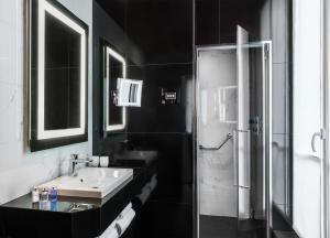 y baño blanco y negro con lavabo y ducha. en Maison Albar - Le Diamond en París