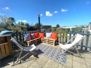 a patio with two chairs and a couch at Camping Paradis 4 étoiles Au Port de L'Houmeau - La Rochelle in LʼHoumeau