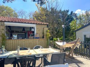 a patio with a table and chairs and a building at Camping Paradis 4 étoiles Au Port de L'Houmeau - La Rochelle in LʼHoumeau