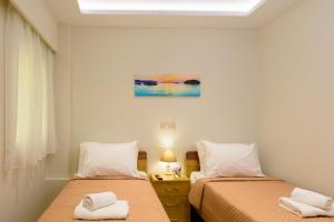 een slaapkamer met 2 bedden en handdoeken bij Melia deluxe apartment in Agios Nikolaos