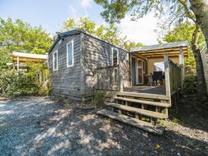 a tiny house with a porch and a deck at Camping Paradis 4 étoiles Au Port de L'Houmeau - La Rochelle in LʼHoumeau