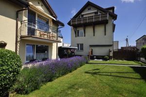 ein Haus mit lila Blumen davor in der Unterkunft Pokoje gościnne Doris in Władysławowo