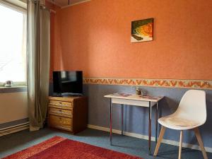 een kamer met een televisie, een tafel en een stoel bij Ferienappartements Dolgesheim 2 in Dolgesheim