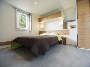 a bedroom with a bed and a window at Camping Paradis 4 étoiles Au Port de L'Houmeau - La Rochelle in LʼHoumeau +37 photos