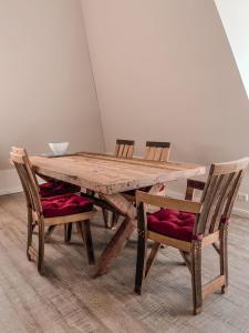 een houten tafel met twee stoelen en een kom bovenop bij Inselperle Kämmererhof in Fehmarn