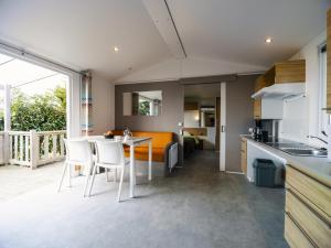 a kitchen and living room with a table and chairs at Camping Paradis 4 étoiles Au Port de L'Houmeau - La Rochelle in LʼHoumeau