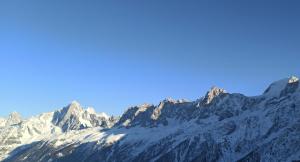 a snow covered mountain range with a blue sky at Duplex Chamonix Les Houches in Les Houches