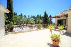 eine Terrasse mit Topfpflanzen vor einem Zaun in der Unterkunft 2 Palaepaphos Gardens in Kouklia