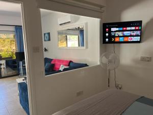 a room with a bed and a tv on the wall at 2 Palaepaphos Gardens in Kouklia