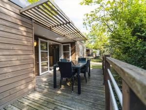 a wooden deck with a table and chairs on it at Camping Paradis 4 étoiles Au Port de L'Houmeau - La Rochelle in LʼHoumeau