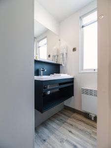 baño con lavabo negro y ventana en Camping 4 étoiles Au Petit Port de L'Houmeau - La Rochelle en LʼHoumeau