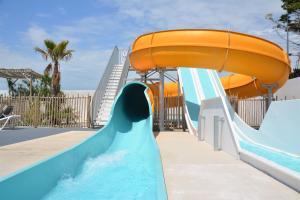 a water slide in a water park with an orange slide at Camping Paradis 4 étoiles Au Port de L'Houmeau - La Rochelle in LʼHoumeau