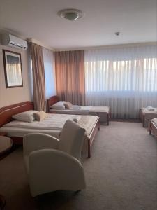 una habitación de hospital con 2 camas y una silla en HOTEL New Milenium en Lukavac