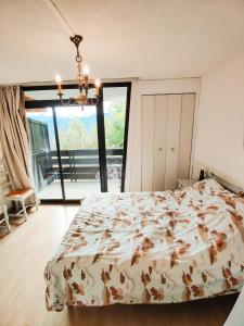 a bedroom with a bed and a large window at Location Pra-Loup Vacances in Pra-Loup