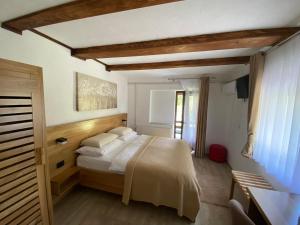 een slaapkamer met een groot bed met witte lakens bij Rada Guest House in Plitvička Jezera