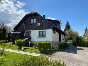 a house with a black and white at Rada Guest House in Plitvička Jezera