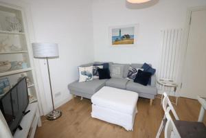 a living room with a couch and a tv at Beachcomber Cottage in Troon