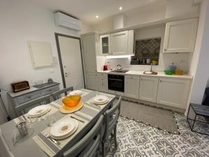 a kitchen with a table with chairs and a sink at Suites 5 Stelle nel Borgo di Varazze in Varazze