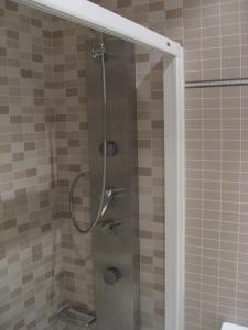 a shower with a glass door in a bathroom at Hotel Machaco in Alburquerque