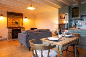 Brosterfield Cottage في Foolow: غرفة معيشة مع طاولة وأريكة