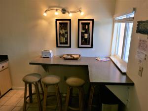 a kitchen with a counter with stools at a bar at Cozy Beach Getaway in Cape Canaveral