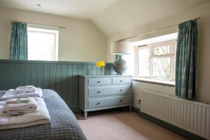 a bedroom with a bed and a dresser and a mirror at Brosterfield Cottage in Foolow
