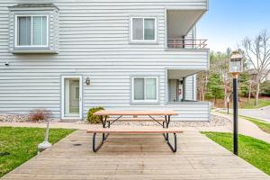 a wooden picnic table in front of a house at Lighthouse Cove Condo Resort in Wisconsin Dells