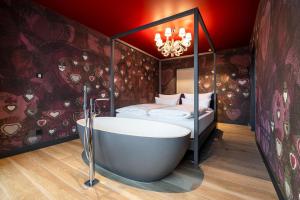 a bathroom with a bath tub and a bed at Laurichhof in Pirna