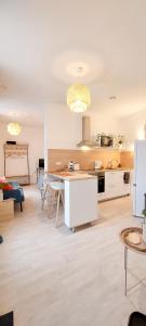 a living room with a kitchen and a table at Artpink - Idéal Pros - Proche commerces - Agathor in Montluçon