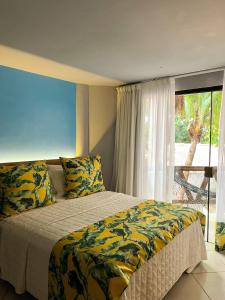 a bedroom with a bed and a large window at Pousada Praia dos Carneiros in Praia dos Carneiros