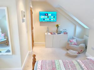 Un dormitorio con una cama y un televisor en la pared. en Loft Room @ Sean and Janes, en Ballycastle