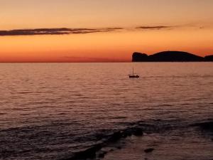 una barca in mezzo all'oceano al tramonto di Ninfa Alghero ad Alghero