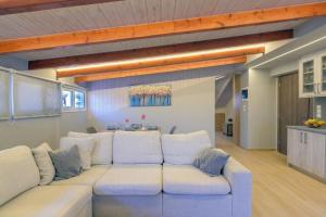 a living room with a white couch and a kitchen at Contemporary Attic in Preveza