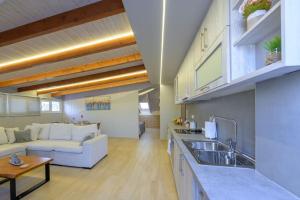 een keuken en een woonkamer met een bank en een tafel bij Contemporary Attic in Preveza