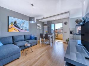 a living room with a blue couch and a table at Apartment Corto Maltese in Dubrovnik