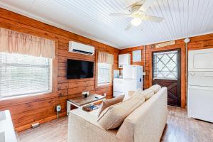 a living room with a couch and a tv at Cozy Cabin in Sevierville